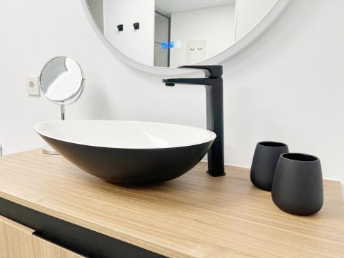 baño con lavabo de tazón negro y espejo en Global Properties, Moderno apartamento con piscina en la playa de Canet, en Canet de Berenguer
