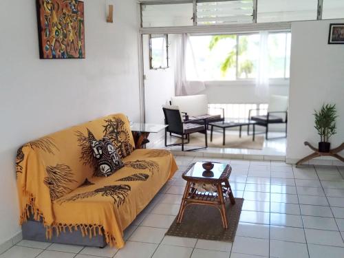 a living room with a couch and a table at Appartement F3 in Le Lamentin