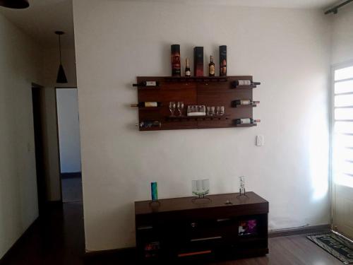 a room with a shelf on the wall with bottles at Apartamento para Temporada, sem vaga de garagem! in Belo Horizonte