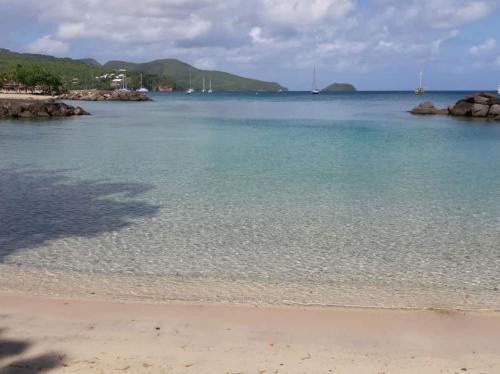 a view of a beach with rocks and the water at Les Tuileries in Les Trois-Îlets
