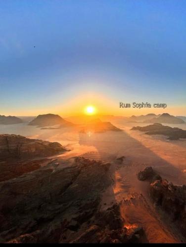 a sunrise in the desert with the sun setting in the horizon at Rum Sophia camp in Wadi Rum