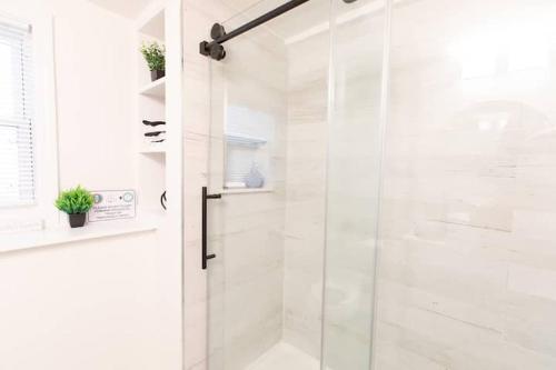 a white bathroom with a shower with a glass door at The Charles-South Shore in Randolph