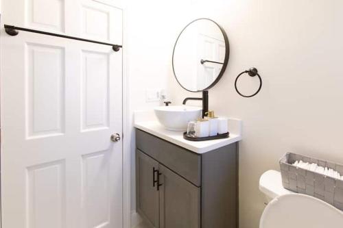 a white bathroom with a sink and a mirror at The Charles-South Shore in Randolph