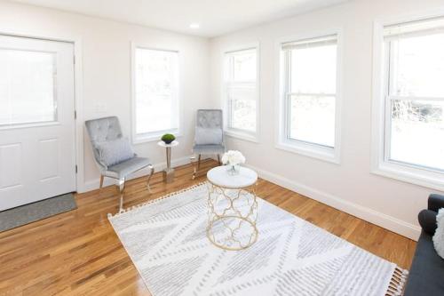 a living room with two chairs and a table at The Charles-South Shore in Randolph