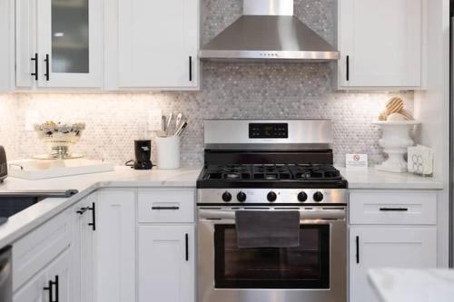 a kitchen with white cabinets and a stove top oven at The Charles-South Shore in Randolph