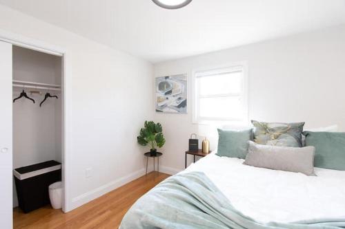 a white bedroom with a bed and a window at The Charles-South Shore in Randolph