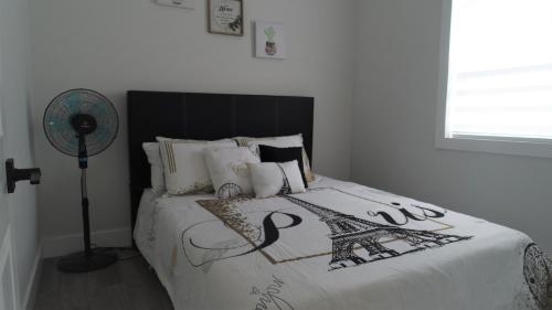 een slaapkamer met een bed met een eiffeltoren-deken bij Charming Retreat on Rothesay Road in Saint John