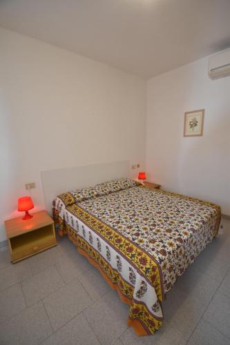 um quarto com uma cama e uma mesa com uma colcha em Appartamento Amapola - Bilocale in zona mare con clima e posto auto em Marina di Campo