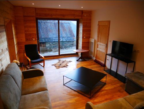 a living room with a couch and a table and a tv at Chalet de Pampo in Vaujany