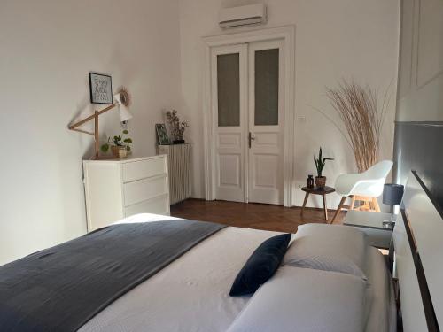 una camera bianca con un letto e una porta bianca di CASA 1903 a Trieste