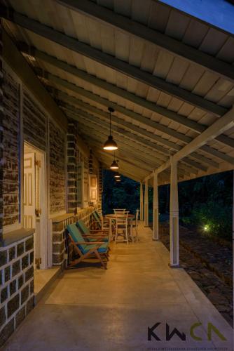 eine überdachte Veranda eines Hauses mit einem Tisch und Stühlen in der Unterkunft Tranquilla in Nikapota