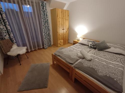クロシチェンコにあるDomek u Kwiatkówのベッドルーム1室(ベッド1台、椅子、窓付)