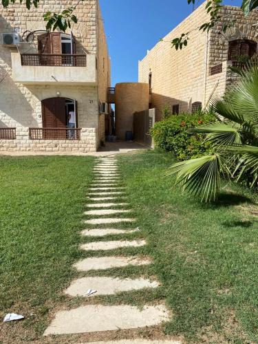 a stone path leading to a building in a yard at اول صف على البحر مارينا العلمين الساحل الشمالي 0إ in El Alamein