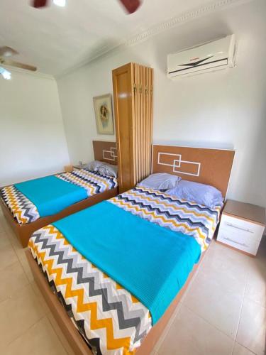 two twin beds in a room with one at اول صف على البحر مارينا العلمين الساحل الشمالي 0إ in El Alamein