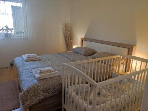 a bedroom with a crib with towels on it at Alacaster in Novi Sad