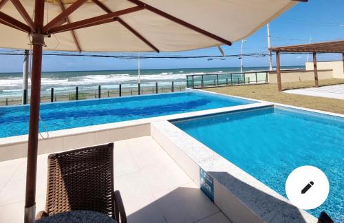 uma piscina com vista para a praia em Apartamento frente mar praia do flamengo em Salvador
