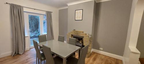 a dining room with a table and a fireplace at Spacious 3 bed House, Wolverhampton in Fallings Park