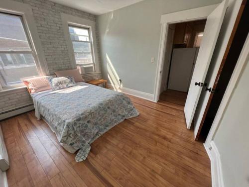 a bedroom with a bed in a room with wood floors at Amazing Location Train/NYC,Cafes in Montclair