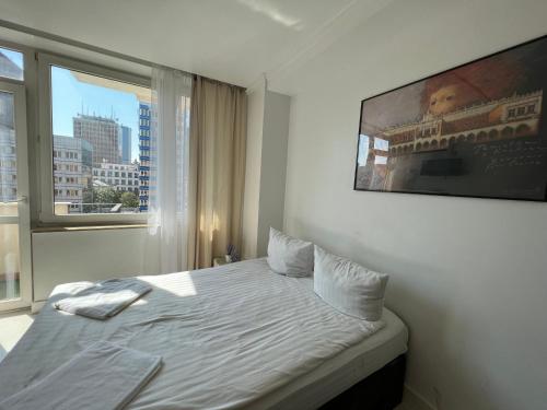 a bedroom with a bed and a large window at Marszałkowska Apartments Studio Central Warsaw in Warsaw