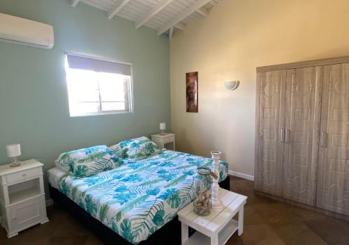 sypialnia z łóżkiem i oknem w obiekcie Pura Vida Aruba Appartement Palma w mieście Noord
