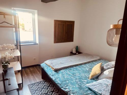 Maison de campagne individuelle et patio في Poulan-Pouzols: غرفة نوم صغيرة بها سرير ونافذة