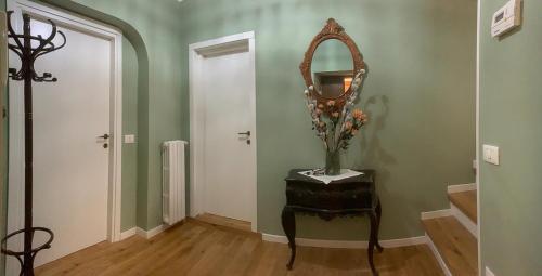 a hallway with a mirror and a table with a vase at Casa in Centro. Nel cuore della città. in Chieti