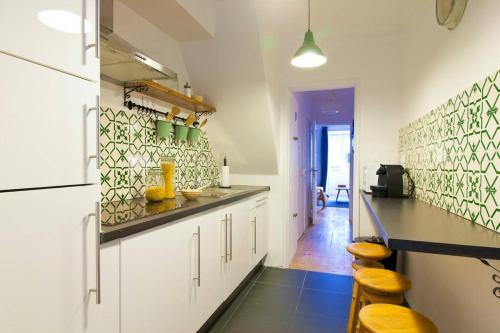 een keuken met witte kasten en een zwart aanrecht bij Lisbon Sant'Anna Apartments in Lissabon