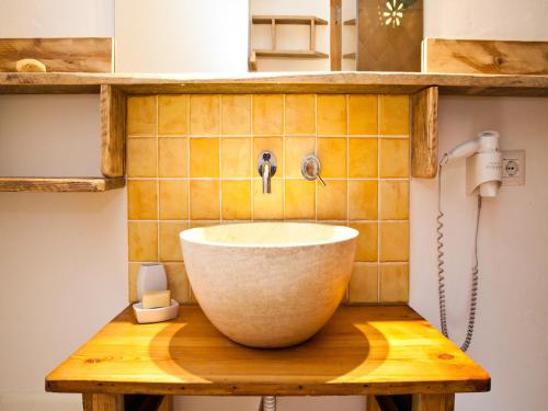 a bathroom with a bowl sink on a wooden table at Smart Appart Sweet Sardinia in Murta Maria