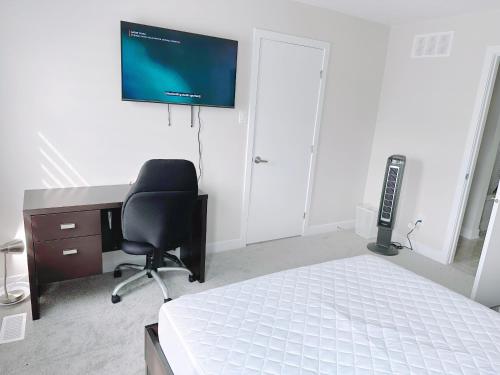 a bedroom with a desk and a chair and a television at Private bedroom in Stittsville