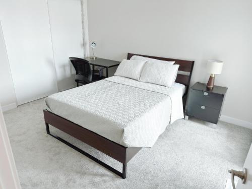 a bedroom with a bed with a table and a desk at Private bedroom in Stittsville