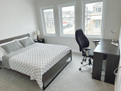 1 dormitorio con cama, escritorio y silla en 2 bedroom ensuite, en Stittsville