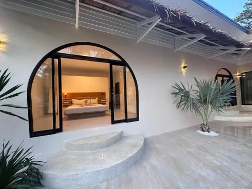 a bedroom with a bed and a large window at Private pool villa in Thongsala
