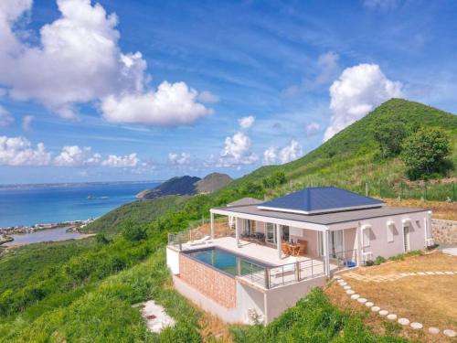 a house on a hill with a view of the ocean at Villa Grand Horizon with extraordinary 180 degree sea view in Saint Martin
