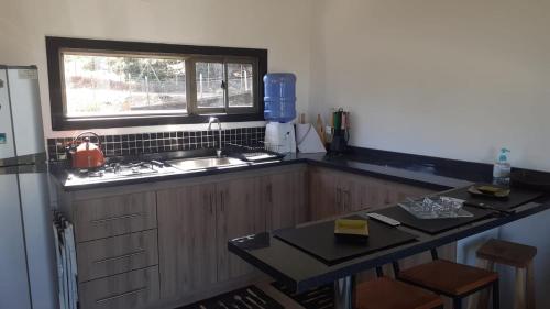 a kitchen with a sink and a counter with a window at Ecobosque y cabañas in Paredones