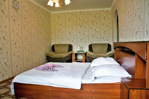 1 dormitorio con 1 cama y 2 sillas en Мельбурн, en Petropavlovsk
