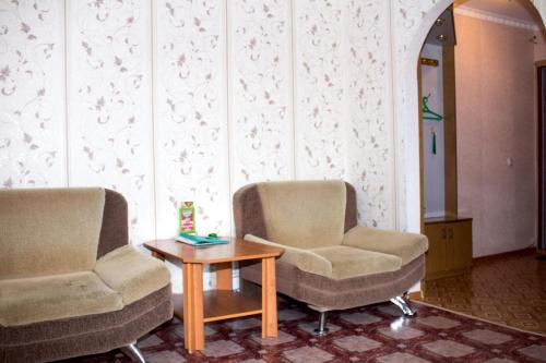 2 sillas y una mesa en una habitación en Мельбурн, en Petropavlovsk