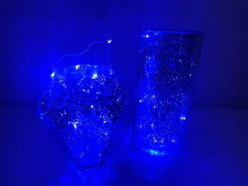 two blue glass vases sitting in a dark room at Casa Enxaimel 02 em Pomerode in Pomerode