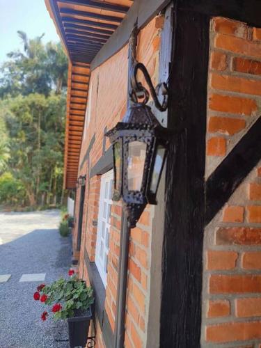 a light on the side of a brick building at Casa Enxaimel 02 em Pomerode in Pomerode