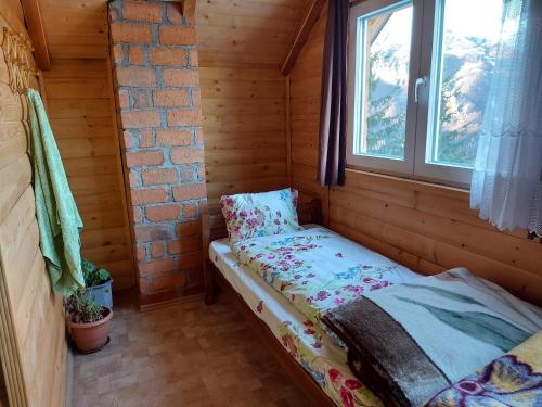 uma pequena cama num quarto com uma janela em Villa Te Ibra em Pec