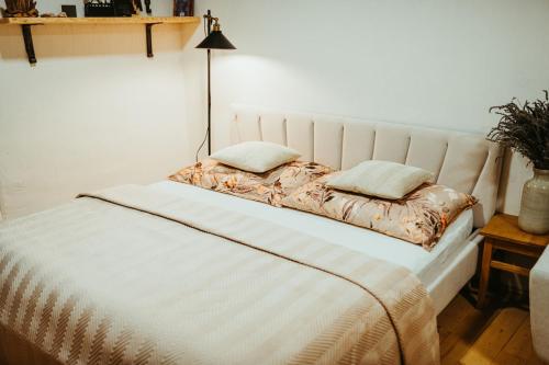 - un lit blanc avec 2 oreillers dans l'établissement Apartmán v Jungovom dome - v centre Štiavnice, à Banská Štiavnica