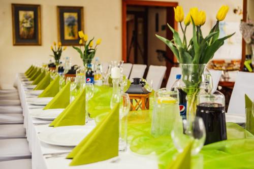 a long table with green napkins and yellow flowers on it at Hotel i Restauracja Nad Jeziorem in Człuchów