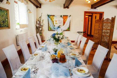 a long table with dishes and flowers on it at Hotel i Restauracja Nad Jeziorem in Człuchów