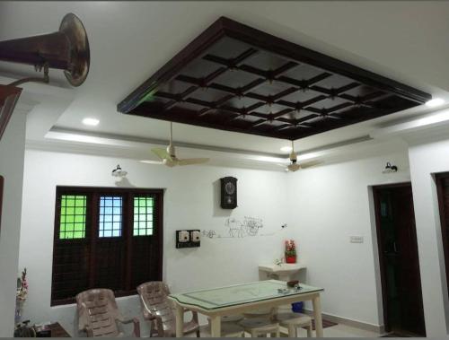 Habitación con mesa, sillas y techo. en Sambranikodi Resort and Home Stay, en Kollam