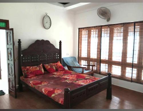 1 dormitorio con 1 cama grande en una habitación con ventanas en Sambranikodi Resort and Home Stay, en Kollam