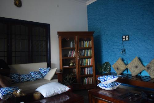 a living room with a couch and a book shelf at Casa De Neel in Puducherry