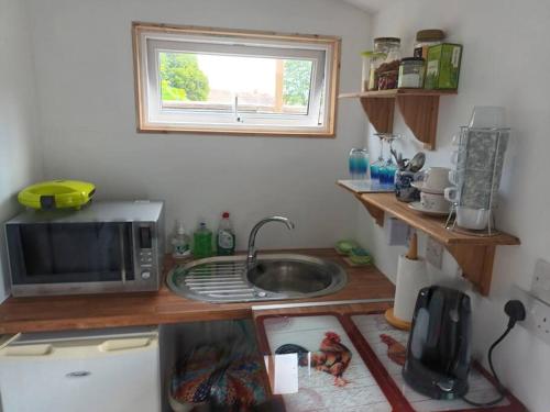 a small kitchen with a microwave and a sink at Private Suite in Oxfordshire, A40 in Witney