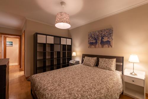 Porto FishLand Apartment في ماتوسينهوس: غرفة نوم بسرير ودهان على الحائط