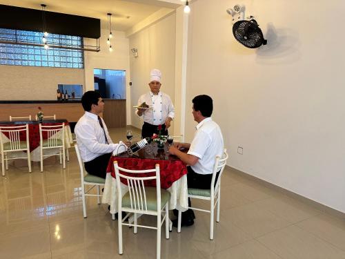 3 Männer sitzen in einem Restaurant an einem Tisch in der Unterkunft Hotel Presidencial in Chiclayo