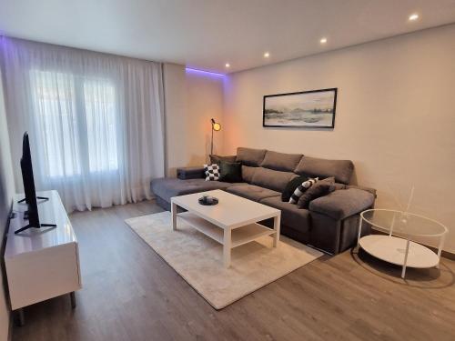 a living room with a couch and a table at Emerald Apartment - Spacious Modern 2 Bedroom in Benalmádena