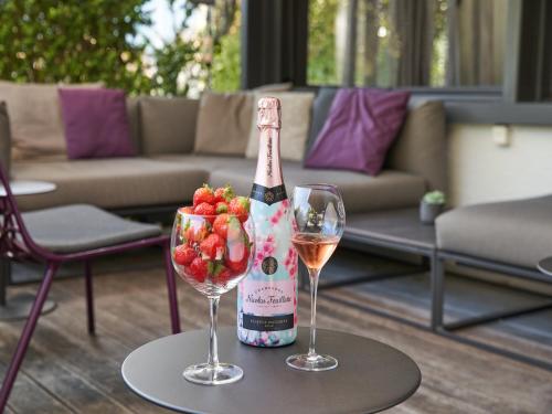 a bottle of wine and two glasses on a table at Victoria - Alpine Boutique Hotel & Fine Dining in Meiringen